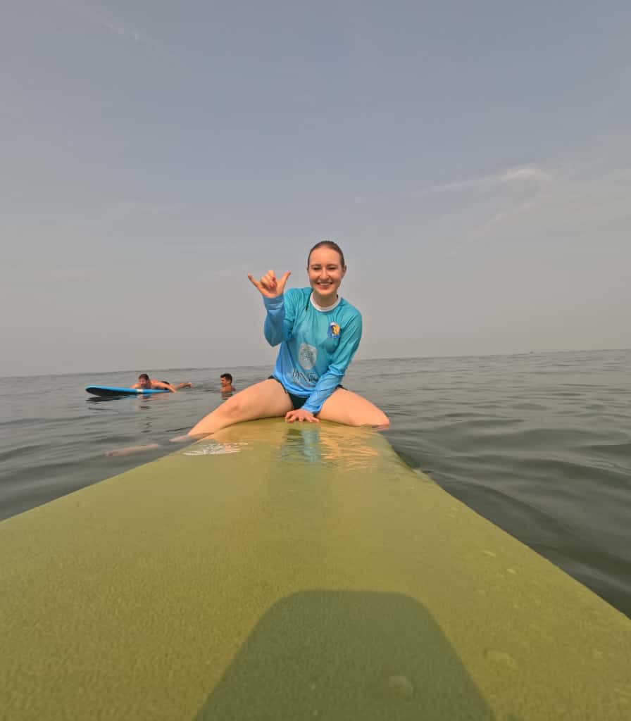 Colorful surfboards lined up on sandy beach ready for surf lessons